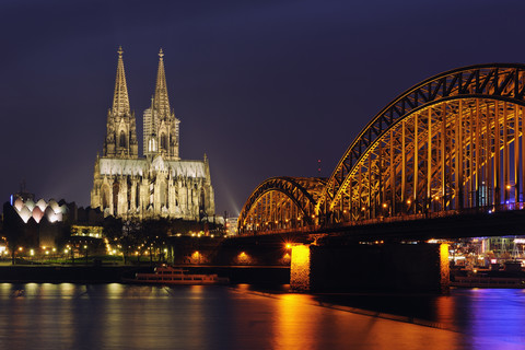 Deutschland, Nordrhein-Westfalen, Köln, Blick auf die beleuchtete Hohenzollernbrücke und den Kölner Dom bei Nacht, lizenzfreies Stockfoto