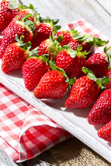 Teller mit Erdbeeren (Fragaria) auf Küchenhandtuch und Jute, Nahaufnahme - MAEF007839