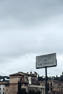 Italien, Rom, Straßenschild mit antiken Gebäuden im Hintergrund - KAF000097