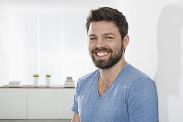 Portrait of young smiling man leaning against wall - PDF000646