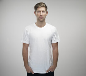 Porträt eines jungen Mannes mit Händen in den Taschen und weißem T-Shirt - RH000303