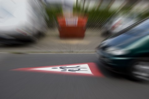 Deutschland, Hessen, Auto fährt bei Warnschild für spielende Kinder zu schnell, lizenzfreies Stockfoto