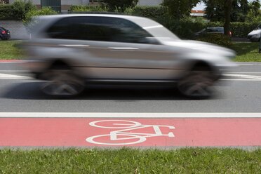 Deutschland, Hessen, Auto fährt neben dem Radweg - AMF001864