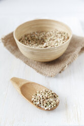 Bowl and wooden shovel of buckwheat grains on white wooden table - EVGF000429