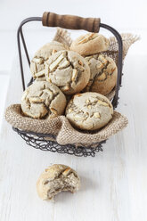 Drahtkorb mit glutenfreien Knoblauch-Buchweizenbrötchen auf weißem Holztisch - EVGF000434