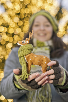 Young woman holding miniature deer with scarf - CLPF000067