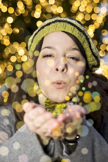 Porträt einer jungen Frau, die goldenen Glitter bläst - CLPF000065