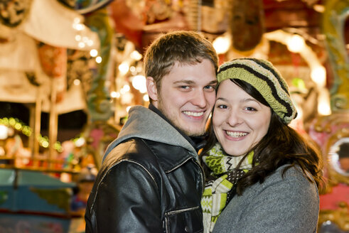 Germany, Berlin, portrait of smiling young couple head to head at Christmas market - CLPF000063