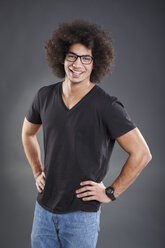 Dark-haired young man in front of gray background smiling - VTF000089