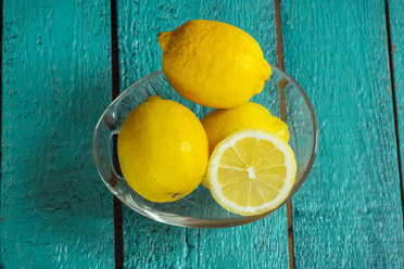 Glasteller mit Zitronen auf grünem Holztisch - SARF000249