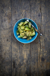 Bowl of avocado salad (Persea americana) on wooden table - LVF000663