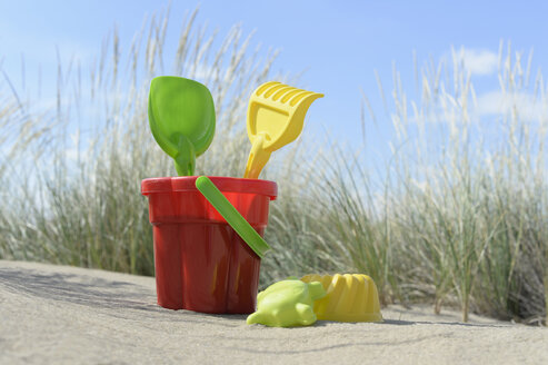 Colourful sandbox toys on sandy beach - CRF002569