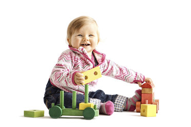 Kleinkind spielt mit Holzspielzeug vor weißem Hintergrund - IPF000012