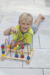 Porträt eines kleinen Jungen, der mit Holzspielzeug spielt - CRF002572