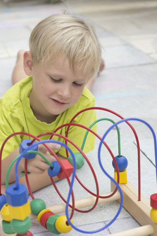 Kleiner Junge spielt mit Holzspielzeug, lizenzfreies Stockfoto