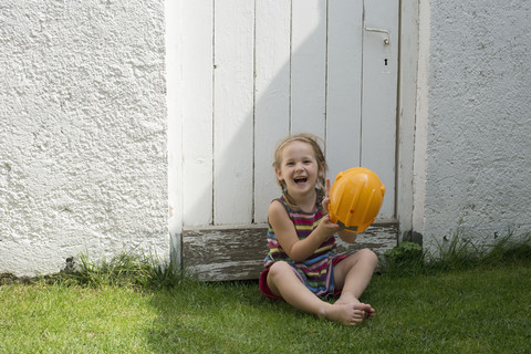 Porträt eines lächelnden kleinen Mädchens mit gelbem Helm, lizenzfreies Stockfoto