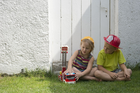 Brother and sister playing fire brigade stock photo