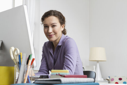 Woman at home sitting at desk with computer - RBYF000333