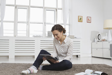 Frau zu Hause mit Tablet-Computer - RBYF000469