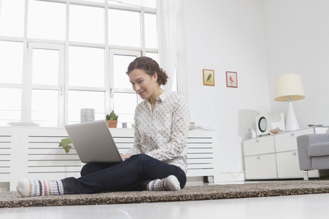 Woman at home using laptop stock photo