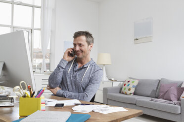 Mann am Schreibtisch beim Telefonieren - RBYF000363