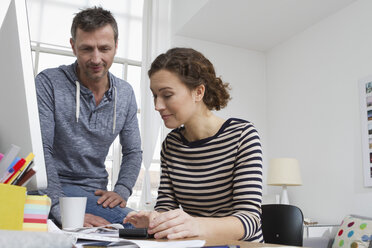 Man and woman at home sitting at desk with bills - RBYF000367