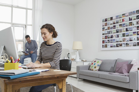 Mann und Frau zu Hause sitzen am Schreibtisch mit Computer, lizenzfreies Stockfoto