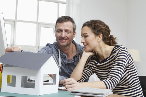 Ehepaar zu Hause mit Modellhaus, lizenzfreies Stockfoto
