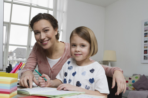 Portrait of mother with daughter at desk stock photo