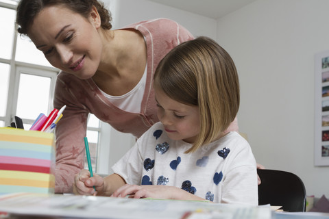 Mutter mit Tochter am Schreibtisch, lizenzfreies Stockfoto