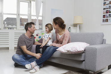 Mutter, Vater und Tochter zu Hause auf der Couch - RBYF000412