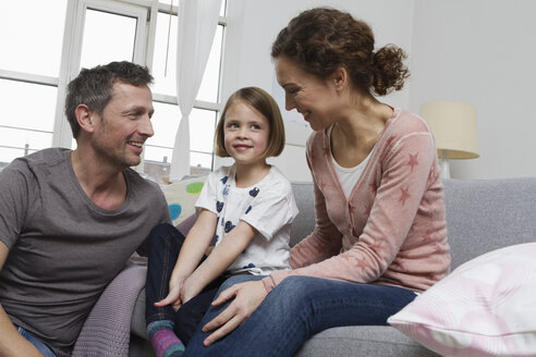 Mutter, Vater und Tochter zu Hause auf der Couch - RBYF000413