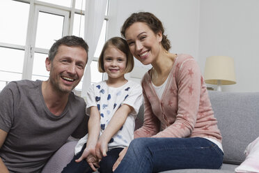 Mother, father and daughter at home on couch - RBYF000414