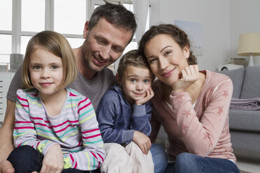 Glückliche vierköpfige Familie im Wohnzimmer - RBYF000461