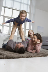 Playful family in living room - RBYF000501