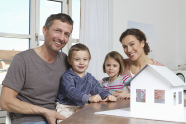 Vierköpfige Familie mit Hausmodell - RBYF000455