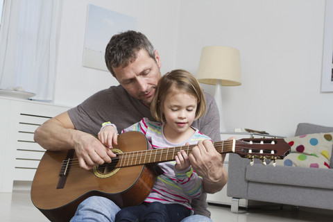 Vater bringt Tochter das Gitarrespielen bei, lizenzfreies Stockfoto