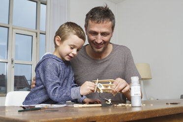 Vater und Sohn basteln an einem Modellflugzeug - RBYF000460