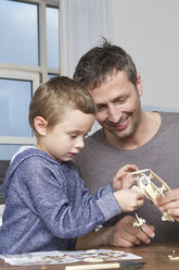 Vater und Sohn basteln an einem Modellflugzeug - RBYF000462