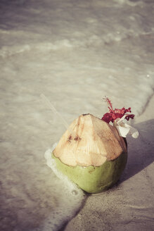 Seychelles, Praslin, coconut with straw at the beach - KRPF000301