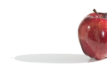 Partial view of red apple with waterdrops on white ground - YFF000042