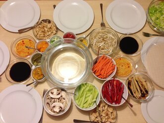 Tischset mit Tellern, verschiedenen Gemüsesorten und Soßen zum Essen vietnamesischer Reisrollen - MEAF000181