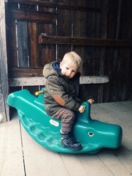 Kleiner Junge reitet auf einem Plastikkrokodil - MEAF000196