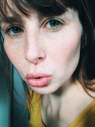 Close-up of woman with freckles blowing a kiss - MEAF000209