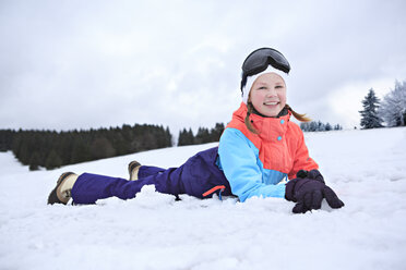Deutschland, Masserberg, Mädchen liegt im Schnee, lächelt glücklich - VTF000094