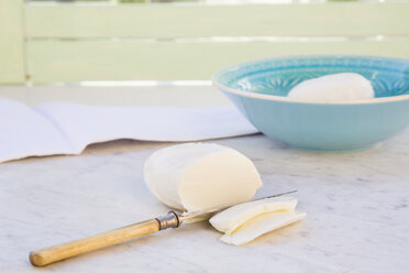Schale mit Mozzarella, geschnittenem Mozzarella und einem Messer auf weißem Marmor - LVF000708