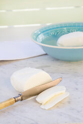 Schale mit Mozzarella, geschnittenem Mozzarella und einem Messer auf weißem Marmor - LVF000707