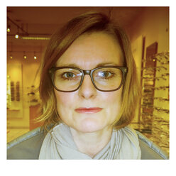 Frau testet verschiedene Brillenmodelle beim Optiker - MAEF007964