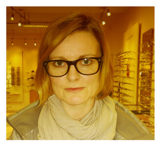 Frau testet verschiedene Brillenmodelle beim Optiker - MAEF007965