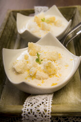 Zwei Schalen mit Lemon-Curd-Creme und zerbröselten Baisers auf einem Tablett, Nahaufnahme - CSTF000035